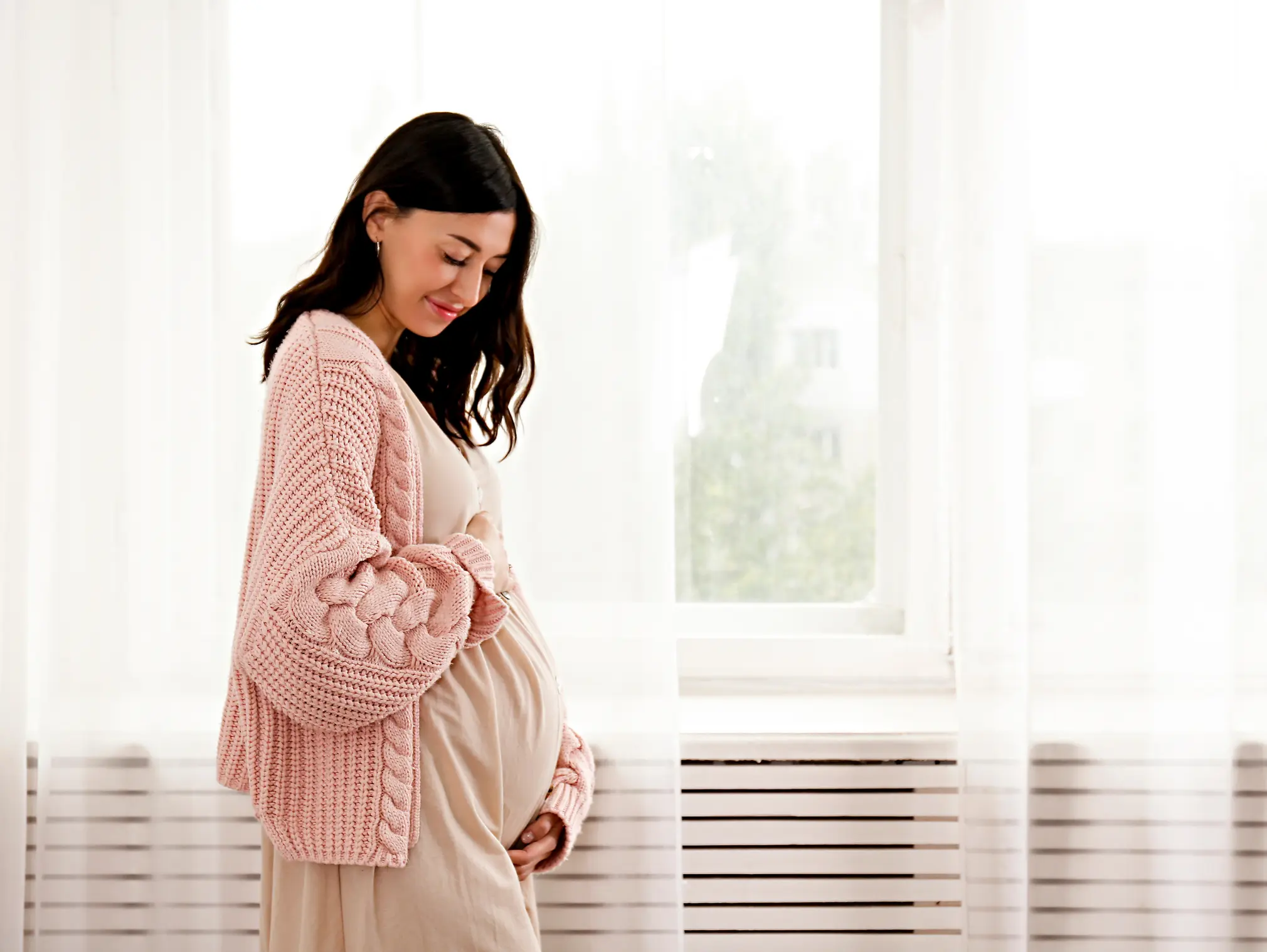 Schwangere legt die Hand auf ihren Bauch: In der Schwangerschaft treten Blasenentzündungen häufig auf.