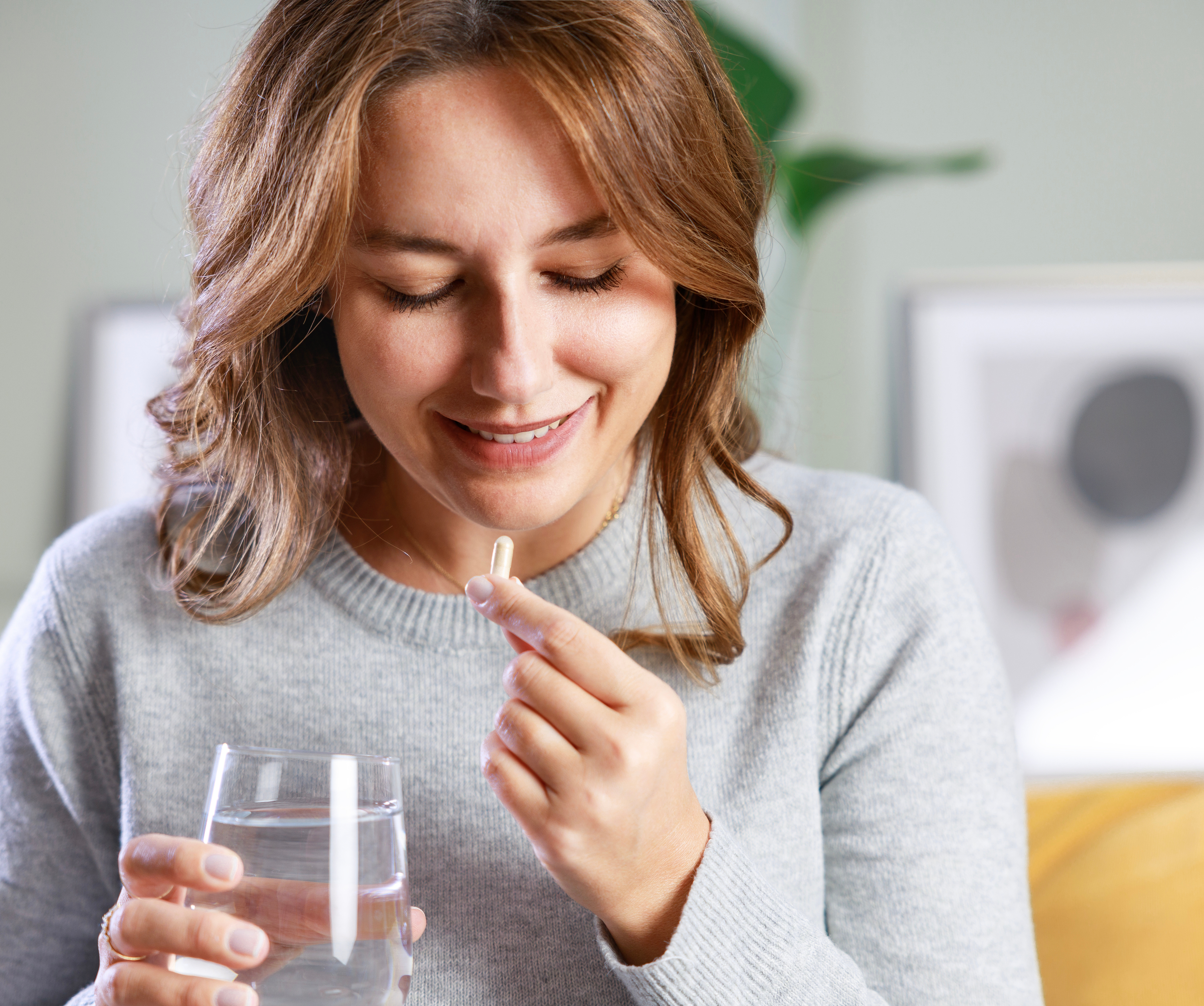 Frau nimmt Antibiotikum bei Blasenentzündung ein.