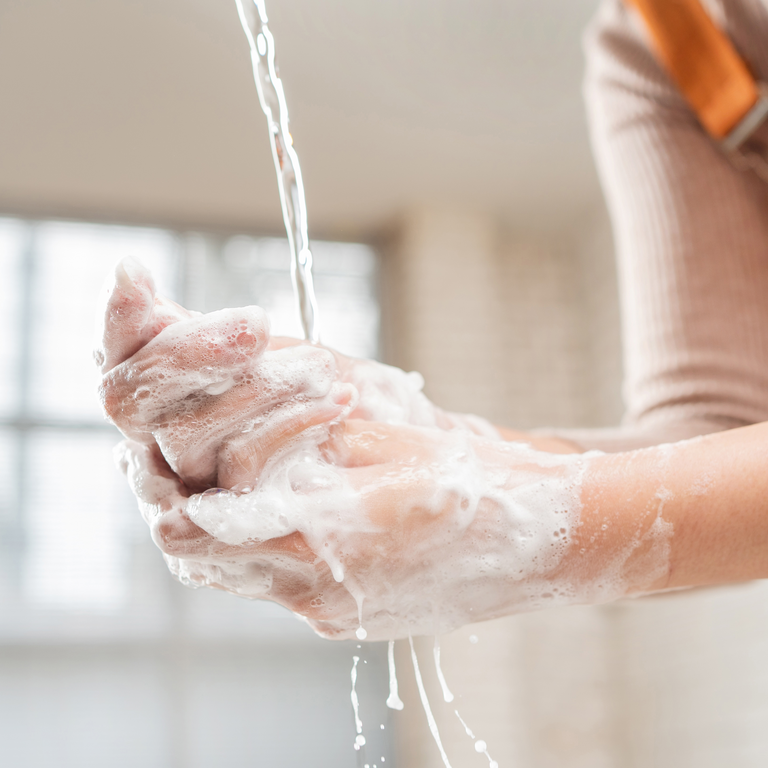 Frau wäscht gründlich ihre Hände, um sich nicht mit einer Blasenentzündung anzustecken.