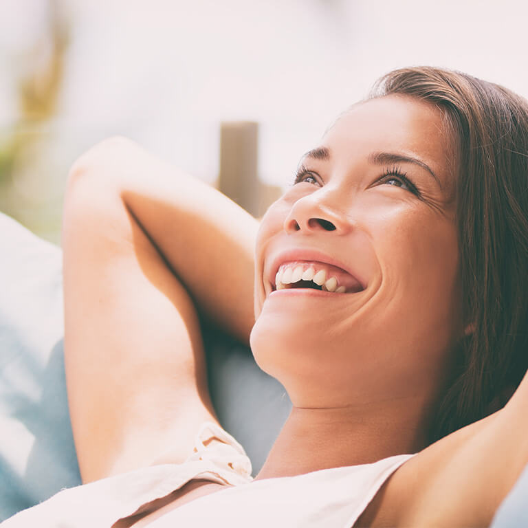 Eine Frau lächelt, weil sie die Symptome einer Blasenentzündung mit der richtigen Therapie überwunden hat. 
